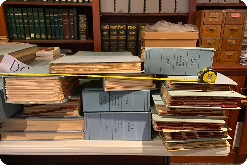 Collection of oversized historical books maps and ledgers being digitized for a museum's online archive
